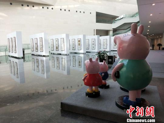 小豬佩奇“一家四口”站立在漫畫展的對面,，正遠遠觀望著,。　楊佩佩 攝