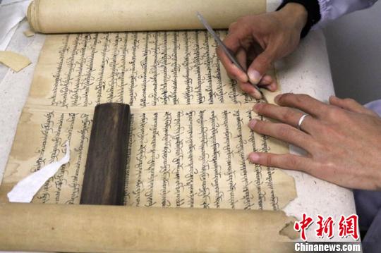 圖為文物保護專家正在對唐代藏文寫經進行修復,。　趙紅云 攝