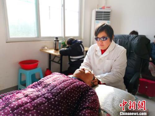 在社區(qū)服務(wù)中心，劉奉智母親為村里人按摩,，劉奉智在一旁寫(xiě)作業(yè),。　郝學(xué)娟 攝
