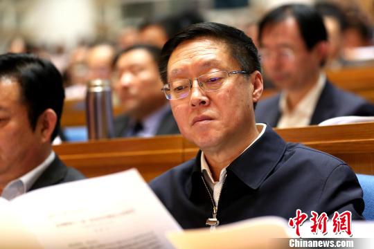 圖為與會政協(xié)委員在現(xiàn)場閱讀會議文件?!×籂?攝 圖為與會政協(xié)委員在現(xiàn)場閱讀會議文件,。 梁犇 攝