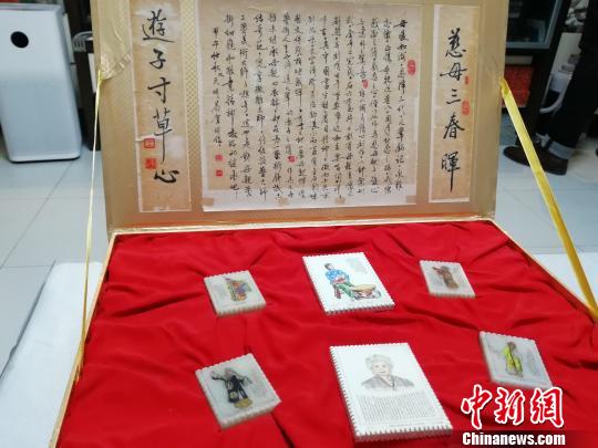 為紀(jì)念母親張春秋,，王天明做了一副微雕作品,，在五塊郵票樣式的玉石上雕畫了張春秋塑造的經(jīng)典舞臺(tái)形象,，并刻上了她的京劇唱詞?！O婷婷 攝