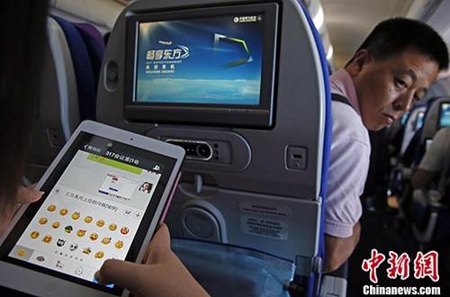 圖為2014年7月23日，旅客在東航實(shí)際承運(yùn)的航班上使用平板電腦(Pad),，進(jìn)行空地互聯(lián)微信聊天,。 <a target='_blank' href='http://www.chinanews.com/'>中新社</a>記者 殷立勤 攝