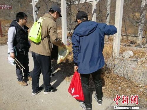 登山隊員們一手握夾子,、一手拎袋子,，開展登山撿拾垃圾活動。招嘉虹/攝 招嘉虹 攝