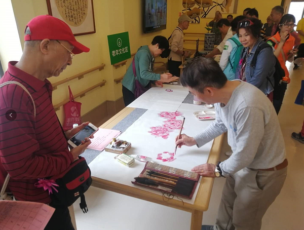 社區(qū)居民揮毫潑墨,，為活動助興