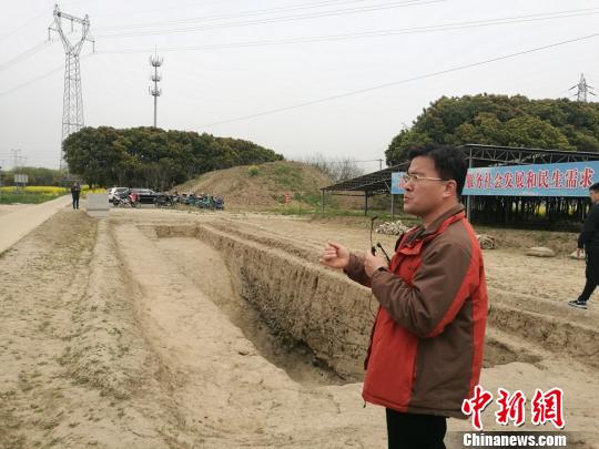 周潤墾在介紹發(fā)掘出的古河道遺址?！＄娚?攝