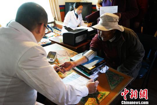 圖為4月10日,，來自西藏阜康(國際)健康體檢中心的彭醫(yī)生(左)為83歲的尼姑旦量血壓?！垈?攝