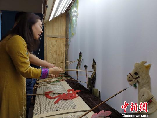 李娟藏在幕布后，繪聲繪色地為觀眾表演《西游記之孫悟空大戰(zhàn)蝎子精》,?！≮w曉 攝