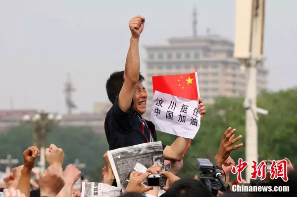 2008年5月19日,，北京天安門廣場上的民眾為地震遇難者默哀，一位來自四川的男子高舉右手為家鄉(xiāng)加油,。中新社記者 富田 攝