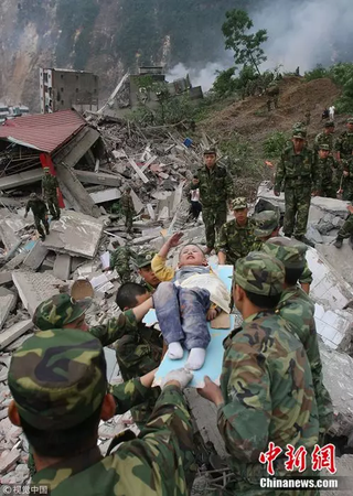 2008年5月13日，3歲的郎錚因為躺在擔(dān)架上向解放軍戰(zhàn)士敬禮,。 楊衛(wèi)華 攝 圖片來源：視覺中國