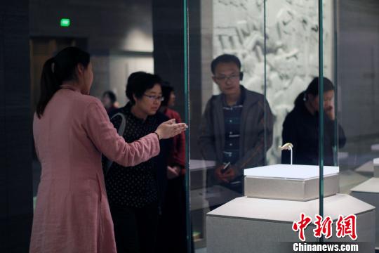 圖為，觀眾在孔子博物館展品前駐足觀賞,，仔細(xì)聆聽講解員解說,。　王飛 攝