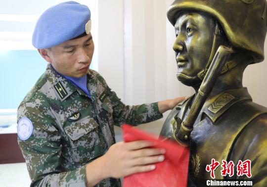卞龍擦拭申亮亮烈士的雕像,。　楊再新 攝