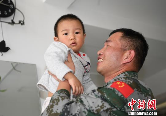 卞龍抱起兒子,。　楊再新 攝