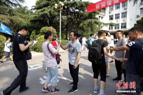 資料圖：2018年6月7日,，山東省實(shí)驗(yàn)中學(xué)考點(diǎn),，考生們陸續(xù)走進(jìn)考場(chǎng)，老師為考生們加油鼓勁,。<a target='_blank' href='http://www.chinanews.com/'>中新社</a>記者 王占波 攝