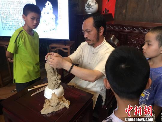 陳明良帶領(lǐng)小游客塑型。吳慧攝