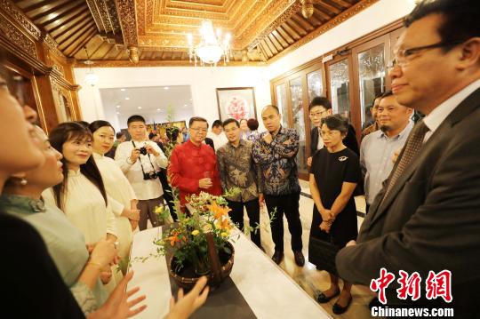 圖為當(dāng)晚在中國(guó)駐東盟大使官邸舉辦的“中國(guó)民俗文化之夜”，各國(guó)外交官賞花藝,?！×钟纻?攝
