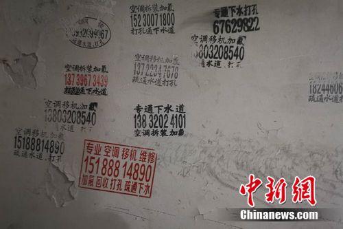圖為北京一小區(qū)樓道內(nèi)的空調(diào)維修小廣告,。 謝藝觀 攝