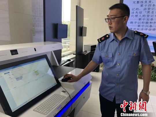 圖為工作人員展示新的系統(tǒng)程序,?！钜?攝