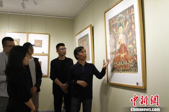 圖為主創(chuàng)者高志勇向參觀嘉賓介紹拍攝作品,?！≮w朗 攝