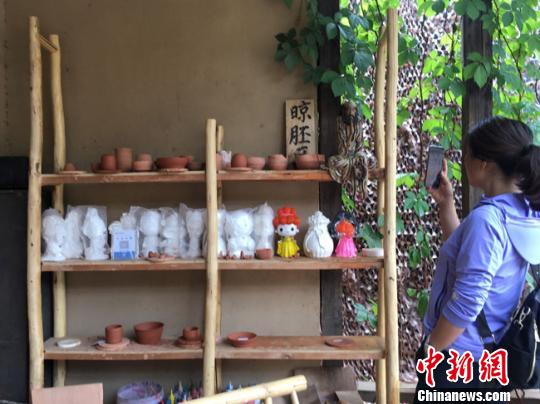 圖為月牙泉小鎮(zhèn)“敦煌彩陶”門口晾胚區(qū)吸引當(dāng)?shù)厝伺恼樟裟??！堟?攝