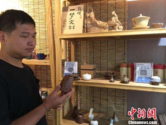 圖為月牙泉小鎮(zhèn)上的敦煌文化癡迷者葉金盛展示文創(chuàng)產(chǎn)品?！堟?攝