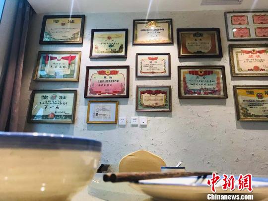 圖為“博物館餐廳”內(nèi)布設(shè)的上世紀獎狀,。　艾慶龍 攝