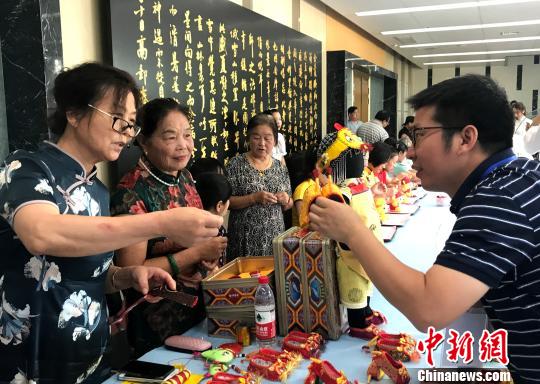 圖為“秦觀故里”高郵三垛七夕習(xí)俗“巧娘娘送巧”——心靈手巧的婦女將自己一針一線手工制作的虎鞋送給孩子?！〈藜衙?攝
