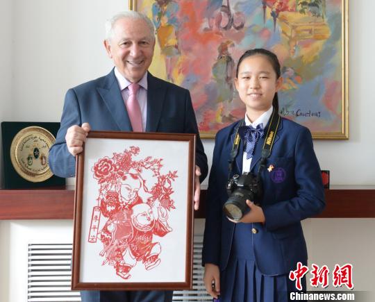 “2019絲路新語,？中外文化小使者巡禮”活動在京啟動,。圖為中國文化小使者向摩洛哥王國駐華大使阿齊茲？梅庫阿爾贈送中國剪紙,。主辦方供圖