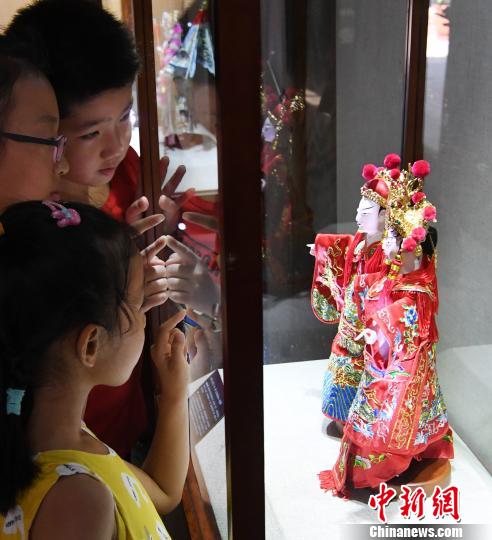 參展木偶頭木雕作品《狀元·夫人》吸引觀展孩子們目光?！∮浾邉⒖筛?攝
