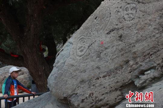 在寧夏賀蘭山巖畫景區(qū)內(nèi),，這在觀看巖畫的游客,。　于晶 攝