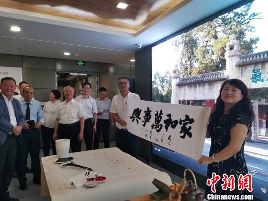 圖為,，慶祝新中國成立70周年外國專家座談會(huì)暨駐濟(jì)外國人才中秋節(jié)沙龍觀上，外國專家展示獲贈(zèng)書法作品,?！O宏瑗 攝