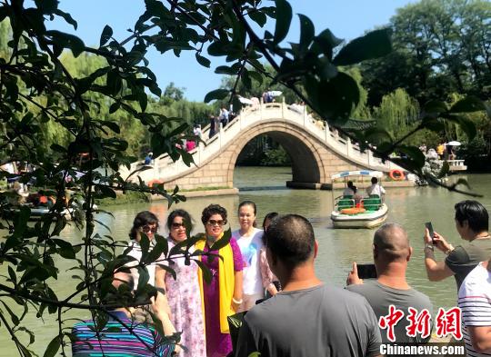 圖為中外游客追逐月亮下?lián)P州,，領(lǐng)略“月亮城”文化魅力,。　崔佳明 攝