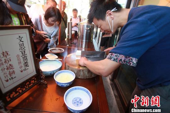 圖為揚州廚師為游客表演淮揚菜經(jīng)典“文思豆腐”的切制,?！∶系慢?攝