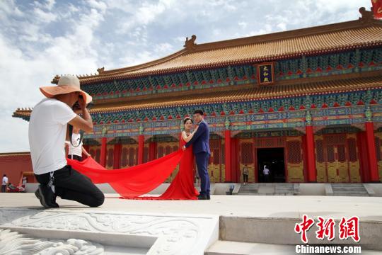 圖為新人在蘭州新區(qū)網(wǎng)紅打卡地“長城影視城”拍結(jié)婚照,?！《P 攝