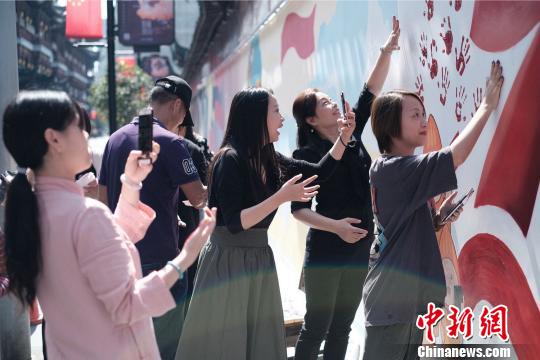 “網(wǎng)紅墻”除了運用了大量知名動畫IP之外，還特別突出了互動性,?！】涤裾?攝