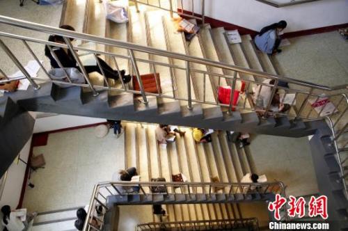 圖為考研生坐在樓梯上專心背誦?！O宏瑗 攝
