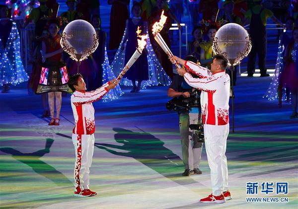 10月18日,，第七屆世界軍人運(yùn)動會開幕式在武漢體育中心舉行。這是火炬手王霜（左）與火炬手劉玉棟在開幕式上交接,。新華社記者 金良快 攝