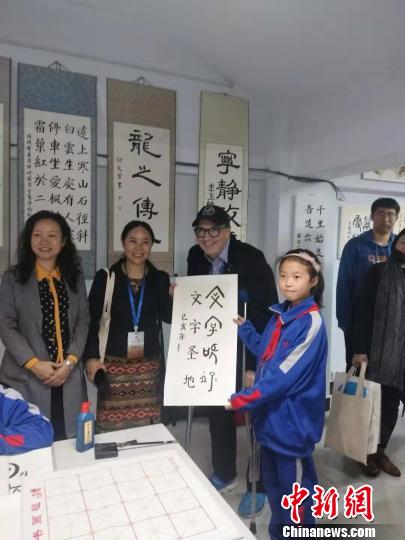 圖為外國漢學(xué)家與孩子交流書法,?！畲笥?攝