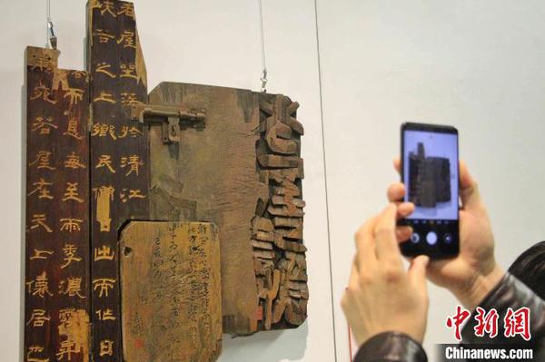 圖為觀眾在刻字作品前駐足拍照?！≮w曉 攝