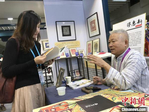 秀洲農(nóng)民畫畫家繆惠新和參觀者交流,。供圖