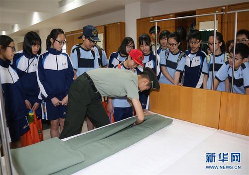 駐澳門部隊在軍營開放活動中邀請市民走進軍營參觀,，戰(zhàn)士們向小學生演示疊軍被（2017年8月24日攝）,。 新華社發(fā)（葉華敏 攝）