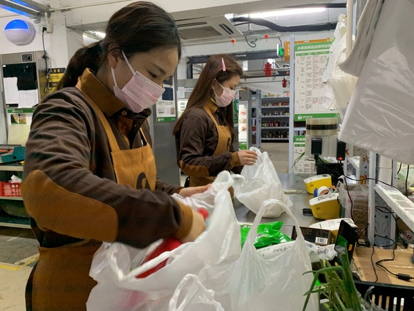 圖為美團(tuán)買(mǎi)菜員工為用戶分裝訂單菜品,。