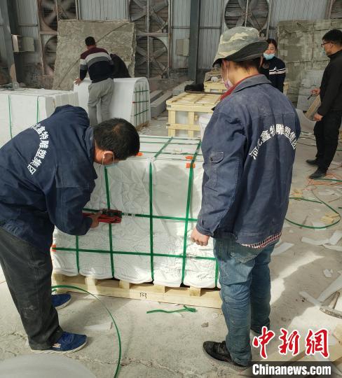 工人們?cè)趯?duì)驗(yàn)收后的《埃塞贊歌》浮雕墻分包裝箱,?！”←慃?攝