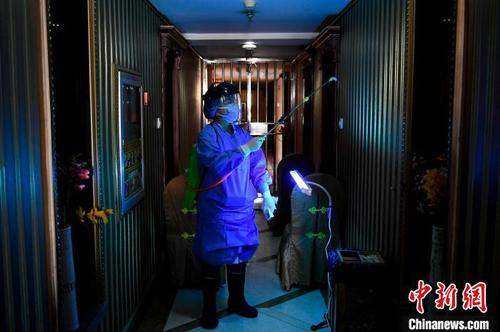 資料圖,。定點(diǎn)隔離酒店人員對(duì)酒店樓道進(jìn)行消毒,。　韋亮 攝