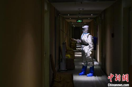 馮丕文穿著厚厚的防護(hù)服在酒店消毒?！∥淇〗?攝