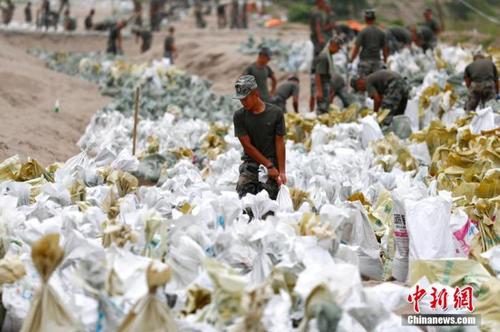 資料圖：7月25日,，江西省九江市柴桑區(qū)江洲鎮(zhèn)北堤,，中國人民解放軍第71集團軍某部官兵正在為防洪備料。