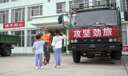 圖為在學(xué)校宿營(yíng)點(diǎn)，小學(xué)生向抗洪官兵官兵敬禮表達(dá)謝意的畫(huà)面,。（付少旋）