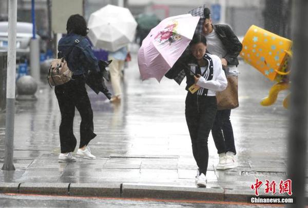 資料圖：市民頂風(fēng)冒雨出行,。 中新社記者 張瑤 攝