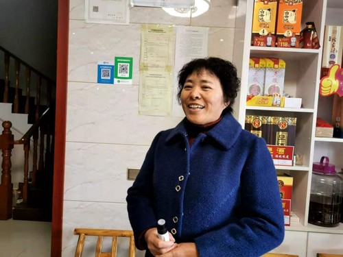 李紀芳向記者介紹民宿經(jīng)營情況,。人民政協(xié)網(wǎng)記者付振強 攝
