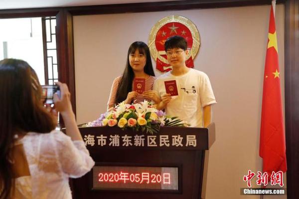 資料圖：兩位市民手持結(jié)婚證合影留念,。 殷立勤 攝