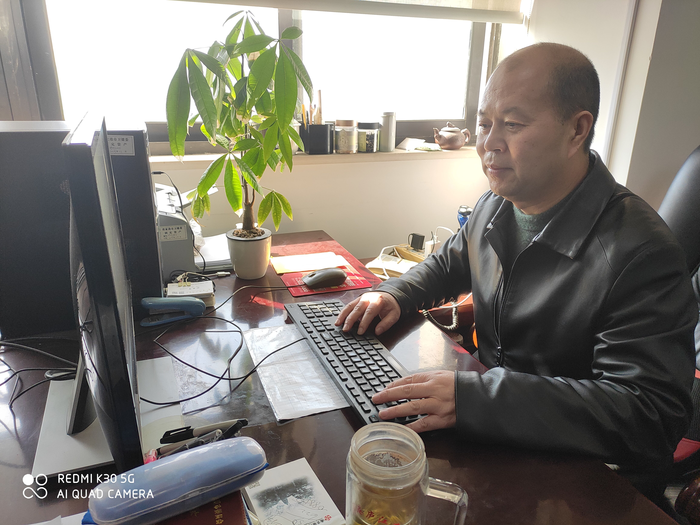 朱長(zhǎng)明委員在家里撰寫社情民意信息